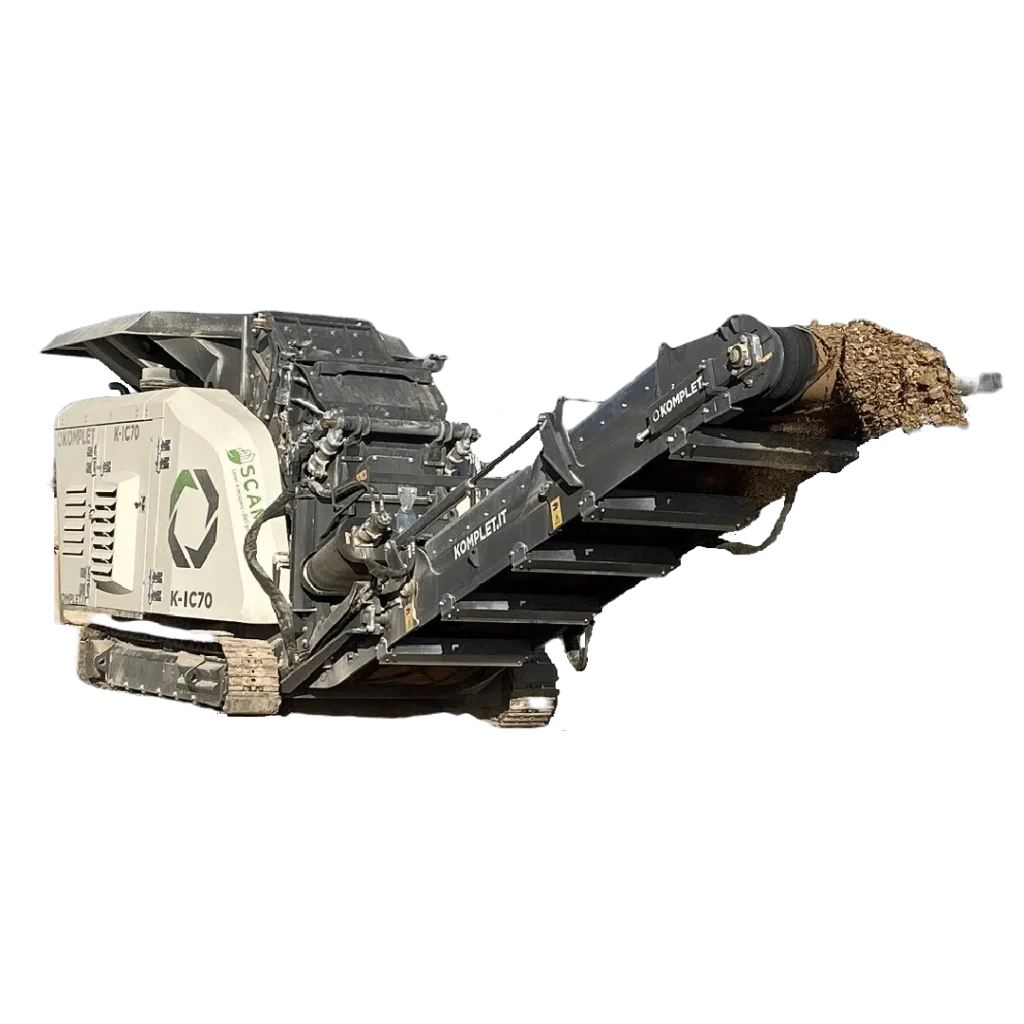 A large, industrial impact crusher is seen conveying crushed material on a moving belt.